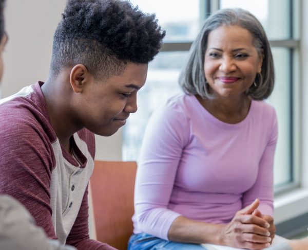 Support High Risk Young person sitting with an adult talking.